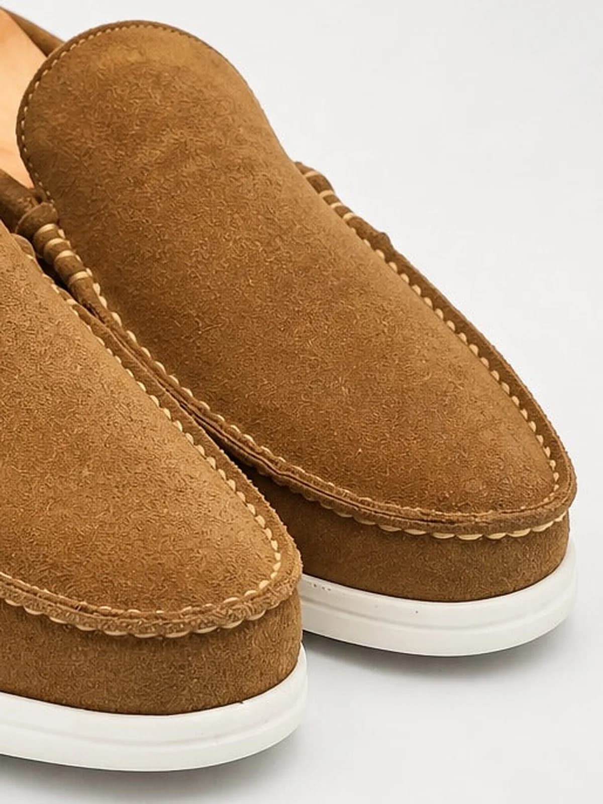 Close-up of the hand-stitched apron seam on a tobacco suede Verona loafer